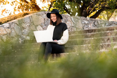 Young woman using laptop on steps