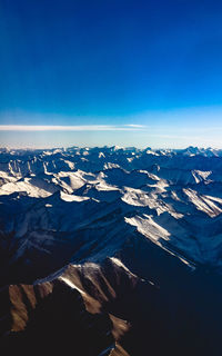 Scenic view of snowcapped mountains against clear blue sky