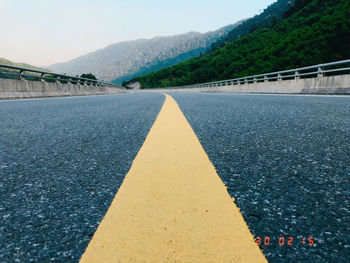 Surface level of road by bridge against sky