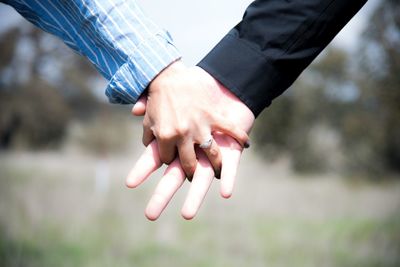 Cropped image of couple holding hands outdoors