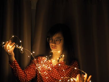 Portrait of woman holding illuminated candles