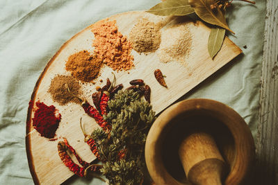 Spices by mortar and pestle on table