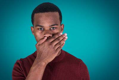 Portrait of young man against blue background