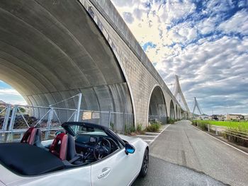 Bridge over road in city against sky