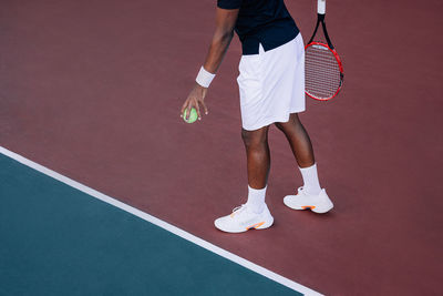 Low section of man standing on playing field