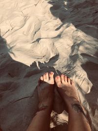 Low section of person legs on sand at beach