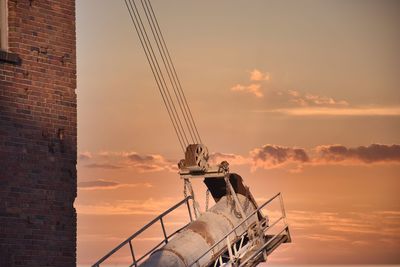 Low angle view machinery against sky during sunset