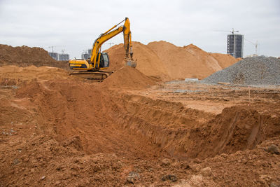 Excavator at earthworks on construction site. backhoe loader digs a pit for the construction 