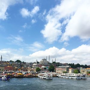 Boats in river with city in background