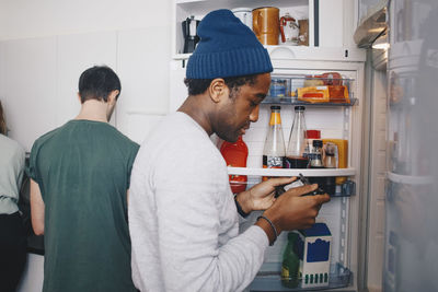 Side view of young man standing at home