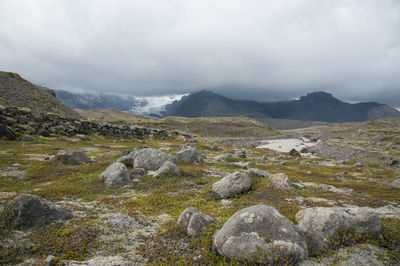 Scenic view of sea and mountains against cloudy sky