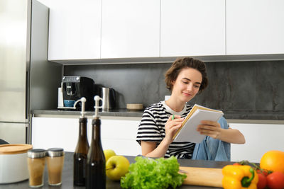 Portrait of smiling young woman sitting at home