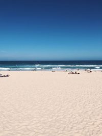 Scenic view of beach against clear blue sky