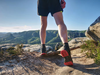 Young man strong legs off trail running at amazing summer sunset in sport and healthy lifestyle