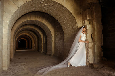 Rear view of woman standing in tunnel