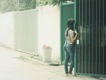 Full length of woman standing by railing
