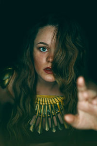 Close-up of beautiful woman against black background