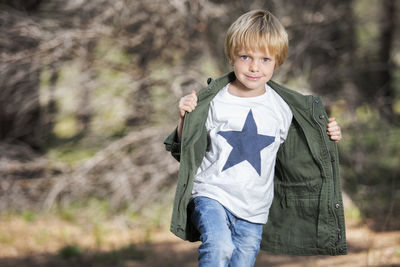 Portrait of boy wearing jacket standing outdoors