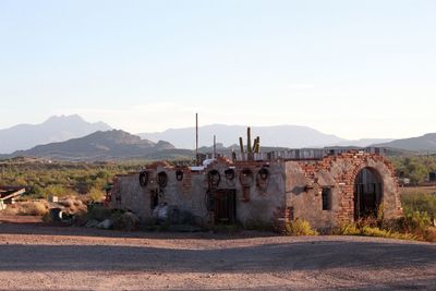 Abandoned built structure on landscape against clear sky