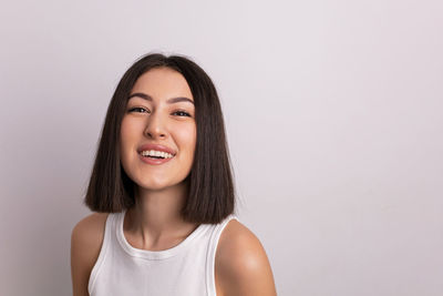 Portrait of young woman against white background