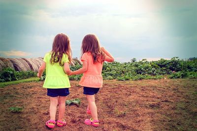 Rear view of girls standing on field