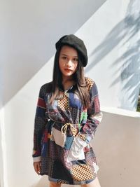 Portrait of girl standing against wall