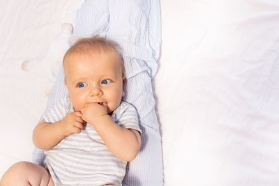 Portrait of cute baby boy lying on bed