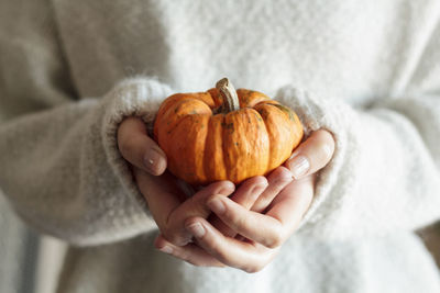 Close-up of hand holding pumpkin