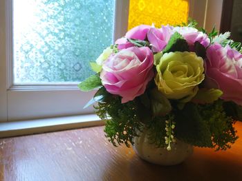 Close-up of pink rose flower vase on table