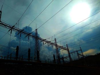 Low angle view of silhouette electricity pylon against sky