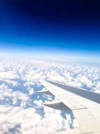 Cropped image of airplane flying over clouds