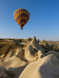 Single hot air balloon above rock formations