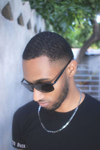 Portrait of young man wearing sunglasses against blurred background