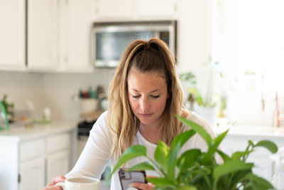 Woman using mobile phone at home