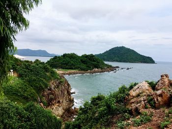 Scenic view of sea by mountains against sky