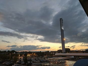 Cars on city against sky during sunset