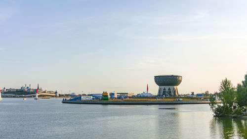 View of boats in river against cloudy sky