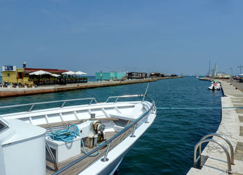 Sailboats moored in sea against clear blue sky