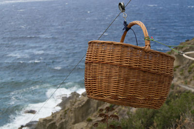 Wicker basket on cable against sea