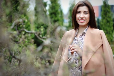 Portrait of a smiling young woman standing outdoors