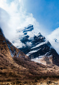 Low angle view of snowcapped mountains against sky