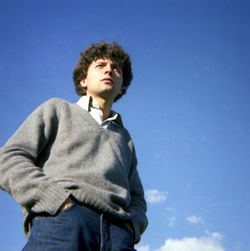 Portrait of young woman standing against clear blue sky