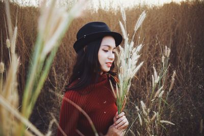 Young woman wearing hat standing on field