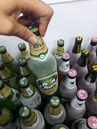 High angle view of hand holding multi colored bottles