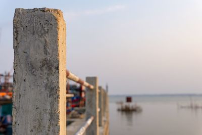 Close-up of wooden post in sea against sky