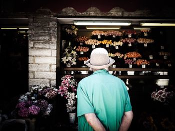 Rear view of senior man against flower store