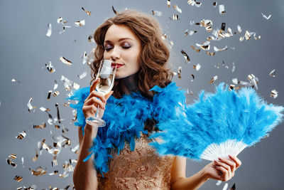 Portrait of young woman flying against blue background