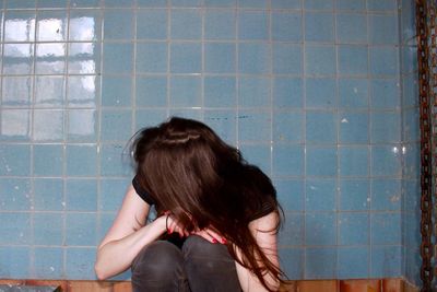 Woman sitting in bathroom