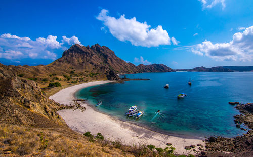 Scenic view of sea and mountains against blue sky on padar island, indonesia