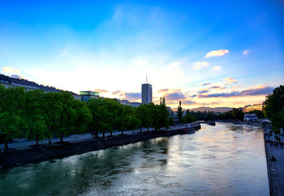 River passing through city buildings at sunset